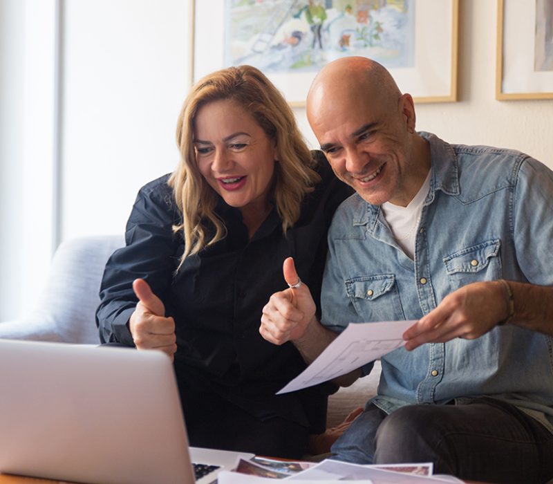 Middle aged couple showing thumb up to laptop screen. Caucasian man and woman in casual using laptop for video call and gesturing like. Positive feedback concept